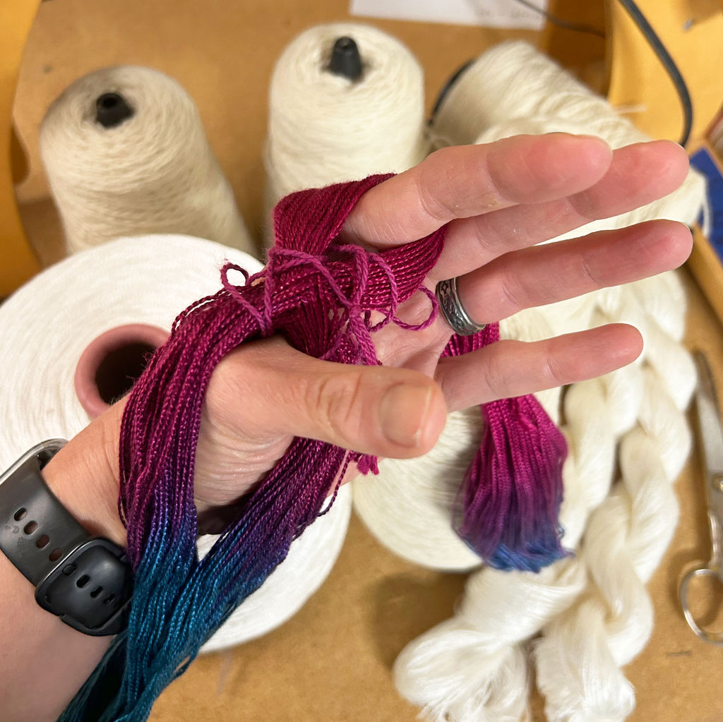 Warping a Rigid Heddle with a Pre-Made SDF Warp; holding a cross on a weaving warp.